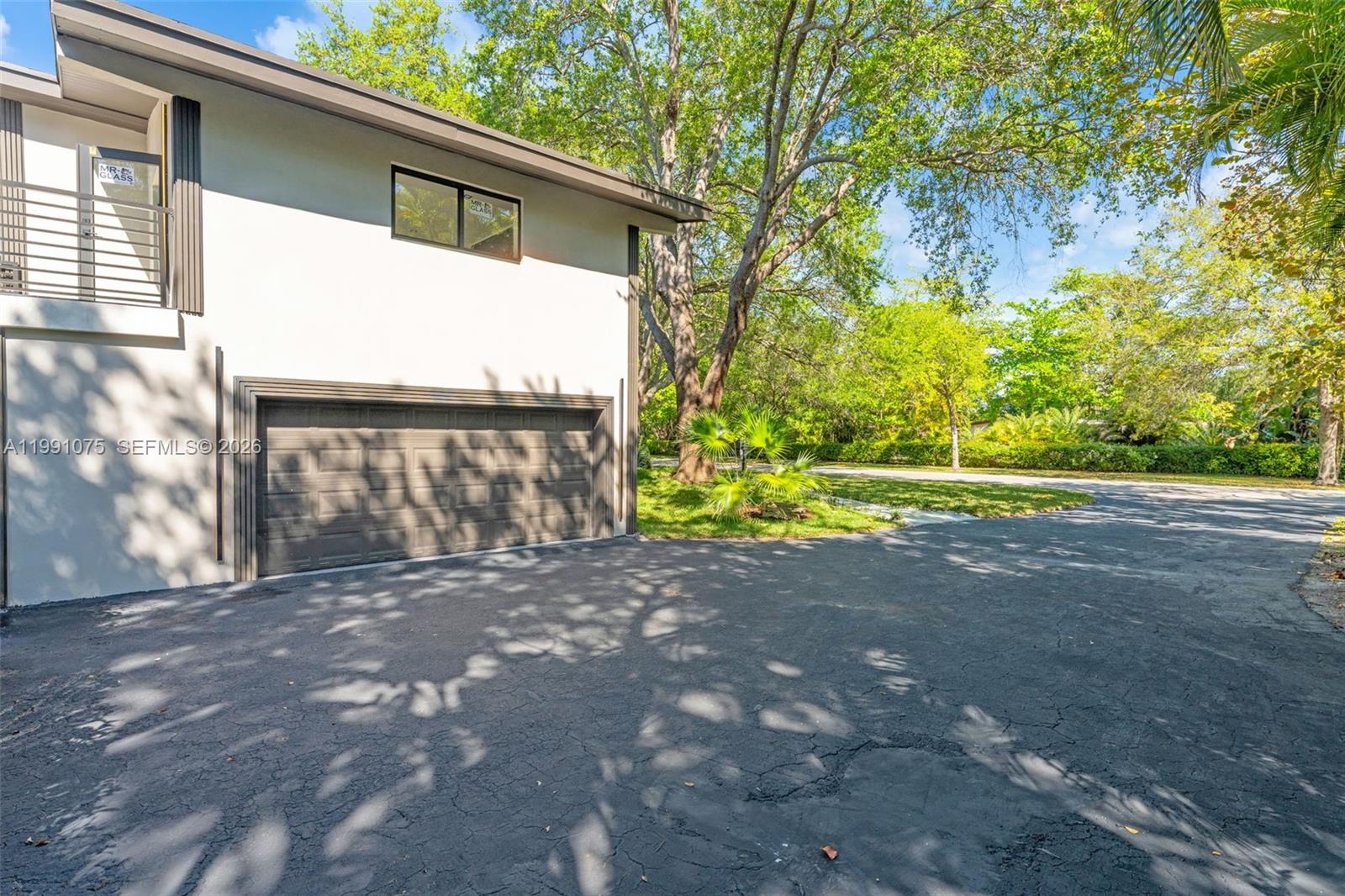 7920 Southwest 132nd Street Pinecrest, FL 33156 - Photo 30 of 45 a side view of a house with a yard and garage