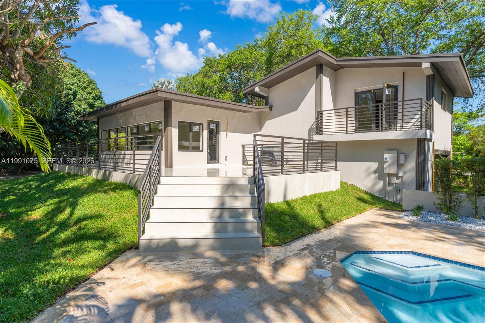 7920 Southwest 132nd Street Pinecrest, FL 33156 - Photo 34 of 45 a front view of a house with a yard and potted plants