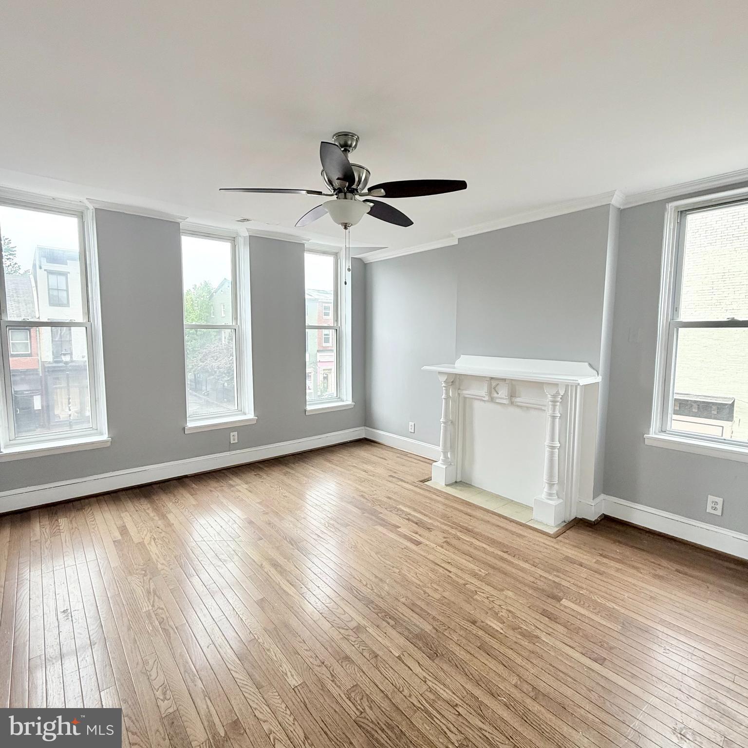 1001 Light Street, Unit 2 Baltimore, MD 21230 - Photo 8 of 11 an empty room with wooden floor chandelier fan and windows