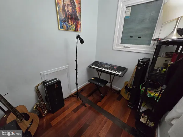 a view of workspace with wooden floor windows gym equipment and mirror