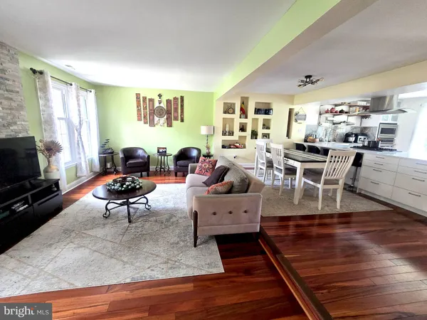 a living room with furniture wooden floor and a window