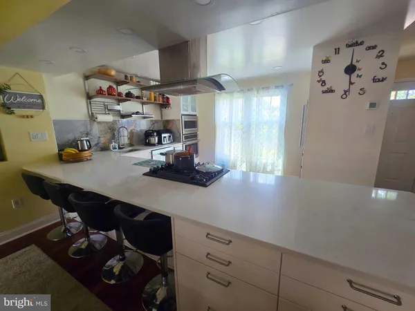 a kitchen with a sink a stove and chairs