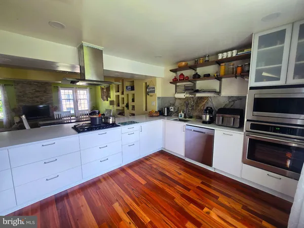 a kitchen with stainless steel appliances granite countertop a refrigerator and wooden cabinets