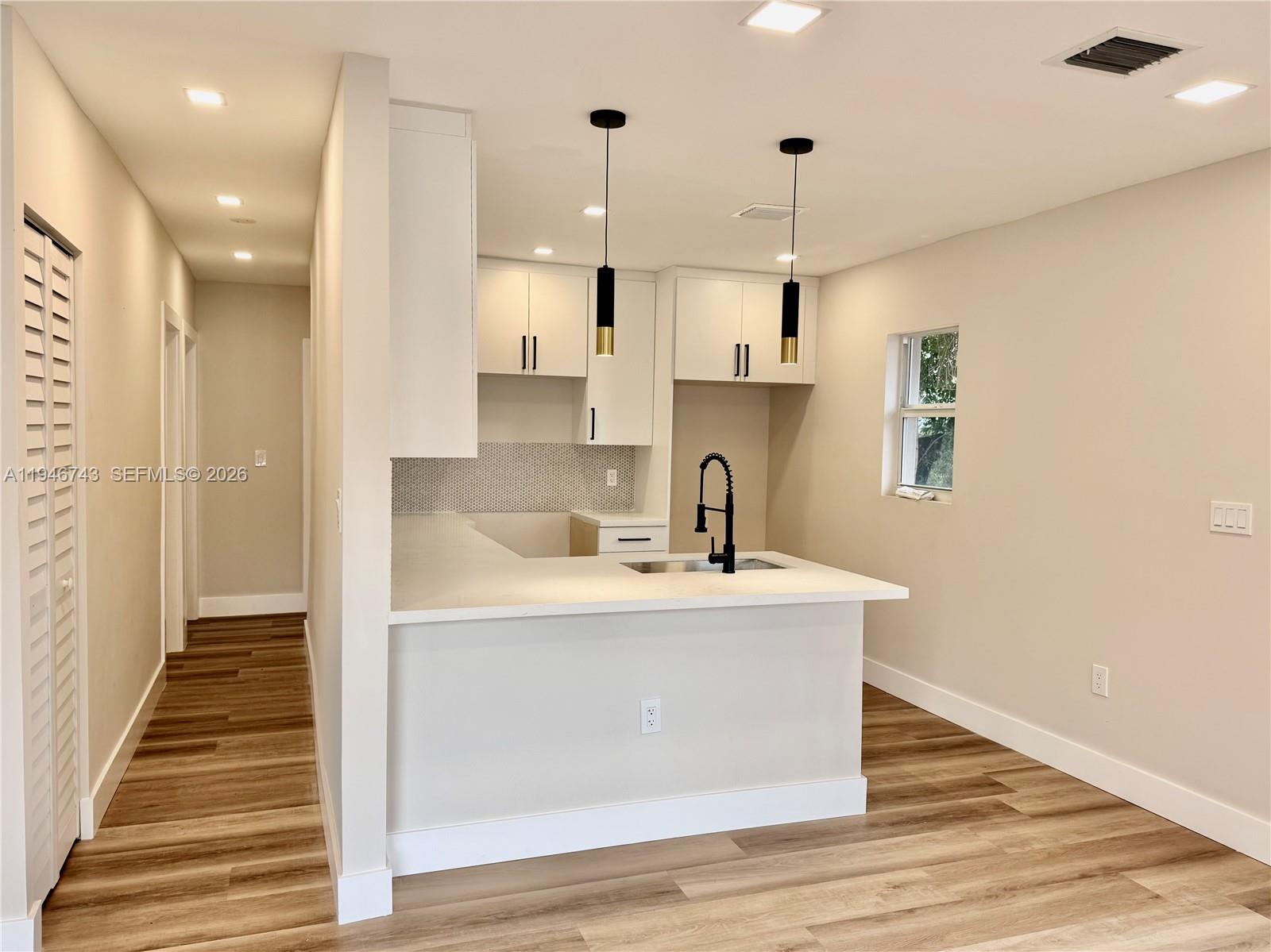 14600 Harrison Street Miami, FL 33176 - Photo 22 of 32 a view of a kitchen with kitchen island a sink wooden floor and living room view