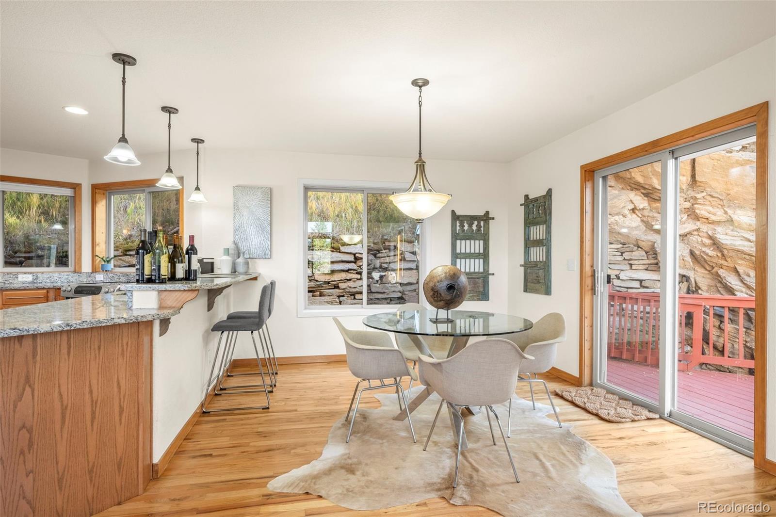 900 Sawmill Creek Road Evergreen, CO 80439 - Photo 22 of 50 a dining room with stainless steel appliances granite countertop a table chairs and a view of living room
