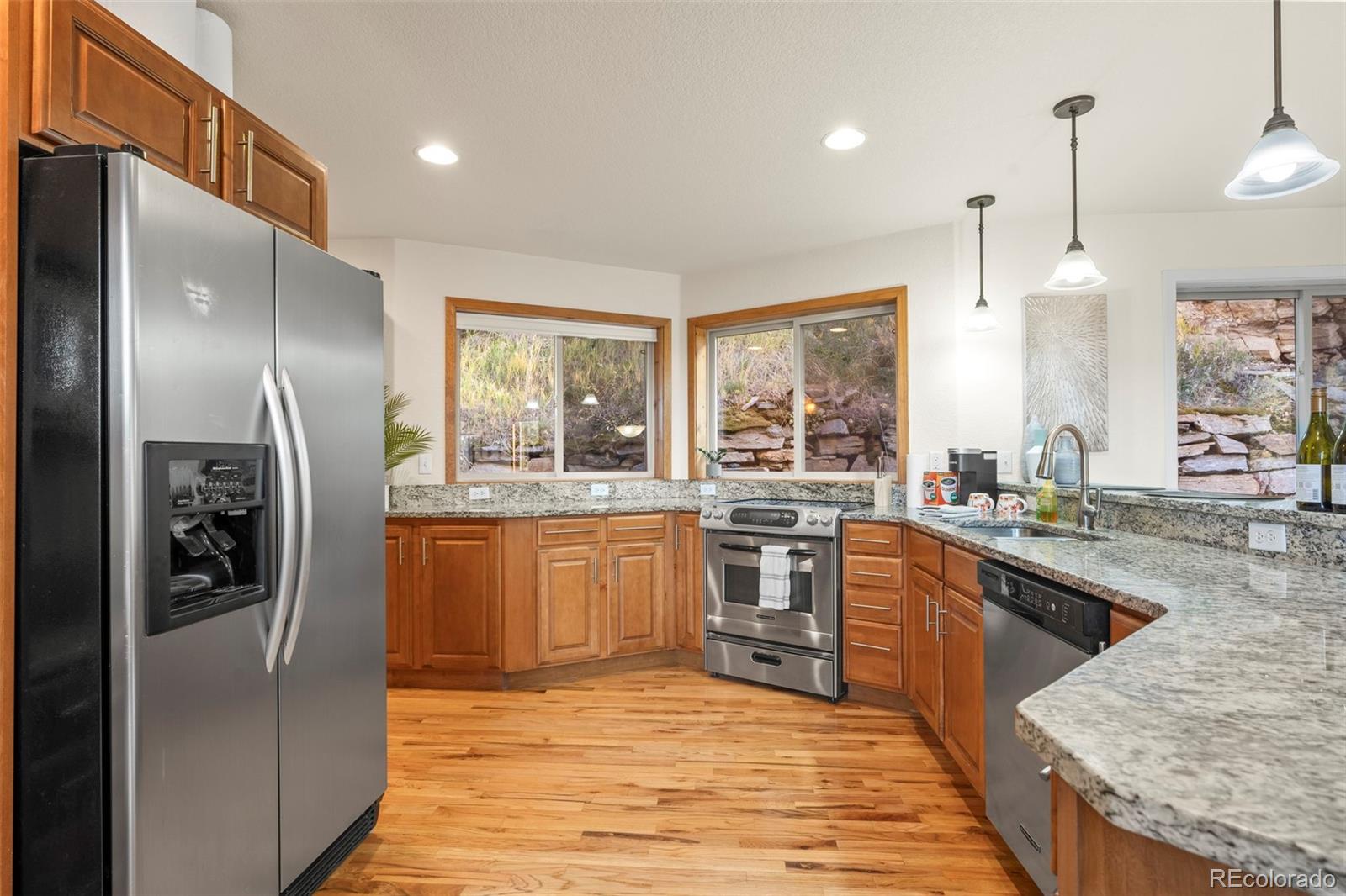 900 Sawmill Creek Road Evergreen, CO 80439 - Photo 26 of 50 a kitchen with stainless steel appliances granite countertop a refrigerator a sink a stove and oven