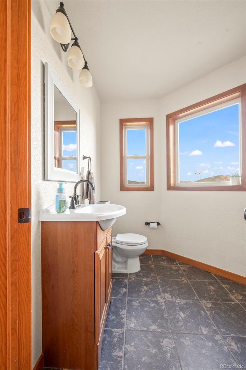 900 Sawmill Creek Road Evergreen, CO 80439 - Photo 29 of 50 a bathroom with a toilet sink and mirror