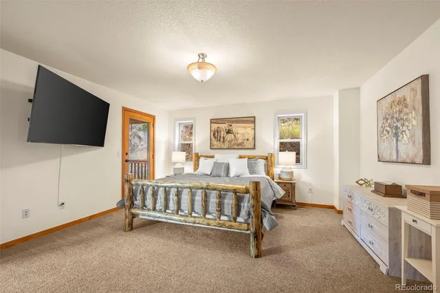 a spacious bedroom with a bed and a flat screen tv