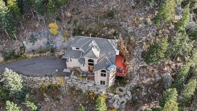 an aerial view of residential house with outdoor space and trees all around