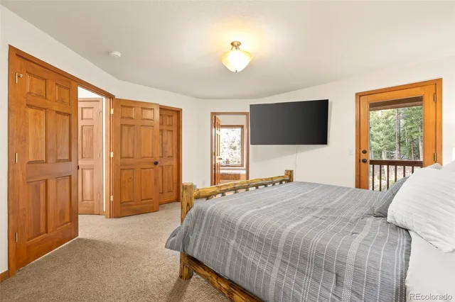a bedroom with a large bed and a flat tv screen on dresser