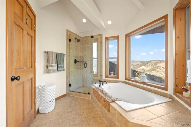 a spacious bathroom with a tub shower and windows