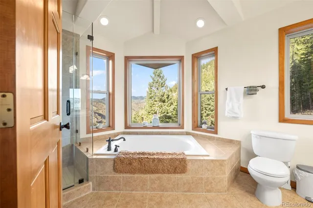 a bathroom with a granite countertop tub sink and a large window