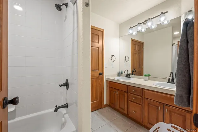 a bathroom with a double vanity sink toilet mirror and bathtub