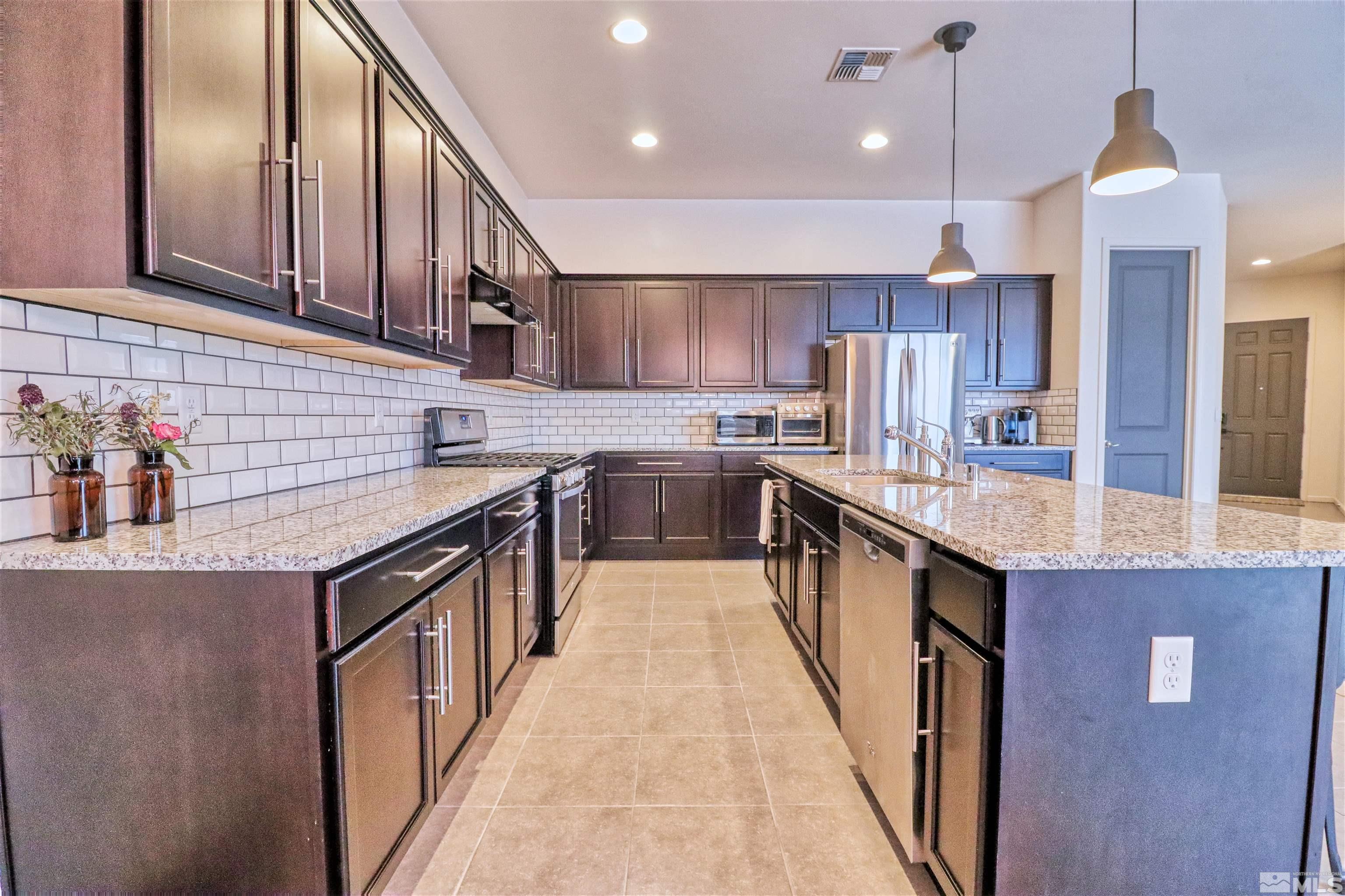 2790 Bonfire Lane Reno, NV 89521 - Photo 11 of 37 a kitchen with stainless steel appliances granite countertop a sink a stove and a refrigerator
