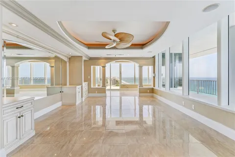 a large white kitchen with a large window and doors