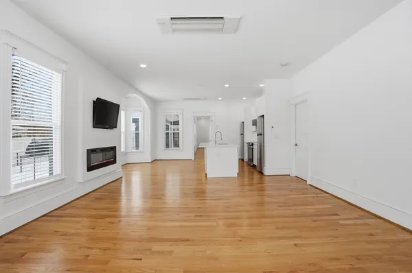 a view of empty room with wooden floor and fireplace