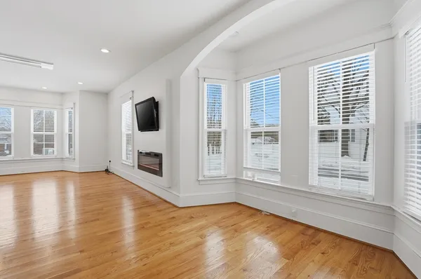 a view of an empty room with a window and fireplace