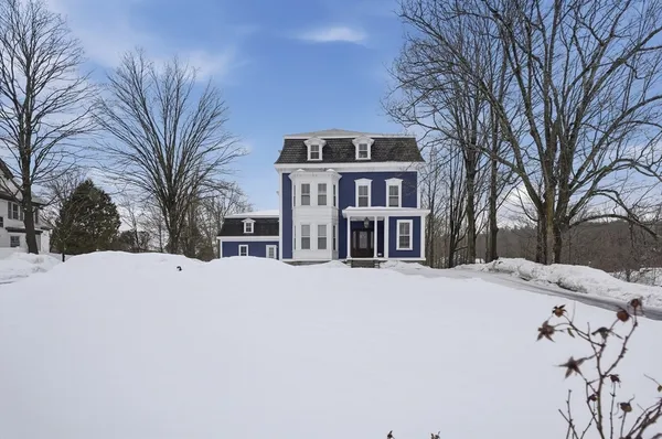 a front view of a house with a yard covered in snow