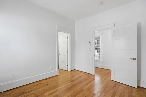 a view of an empty room with wooden floor