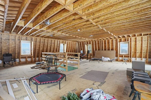 a room with gym equipment and large windows