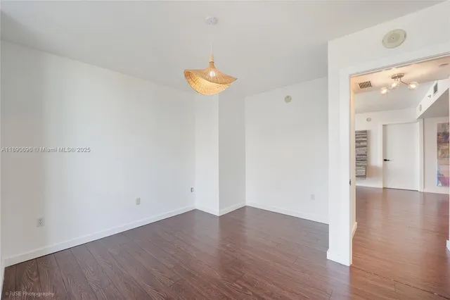 a view of a room with wooden floor and a window