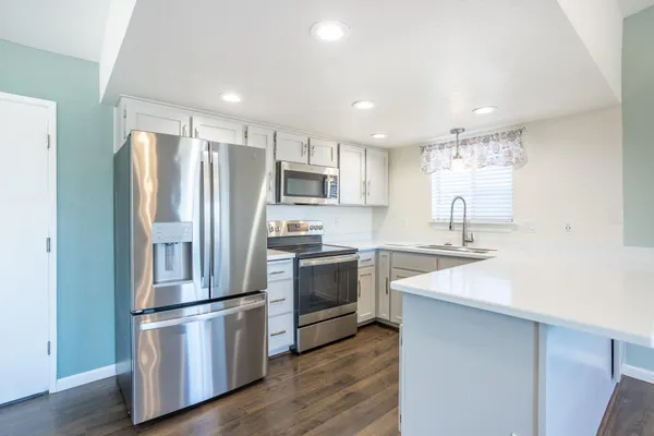 a kitchen with stainless steel appliances a refrigerator sink and microwave
