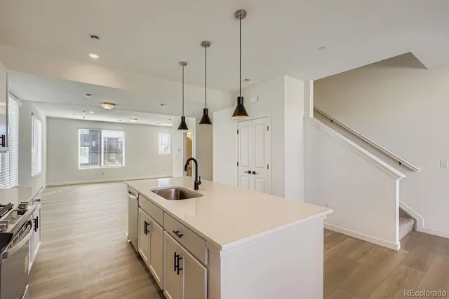 a kitchen with a sink a counter space and wooden floor