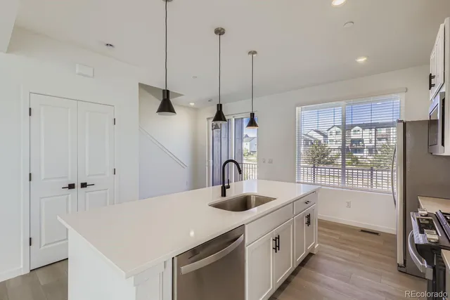 a kitchen with sink a faucet and chairs