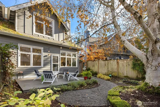 a view of a patio with couches table and chairs potted plants and large tree