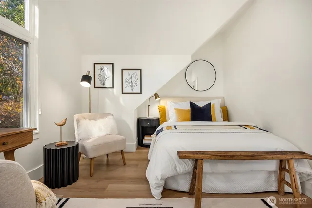 a bedroom with a bed a mirror and a window