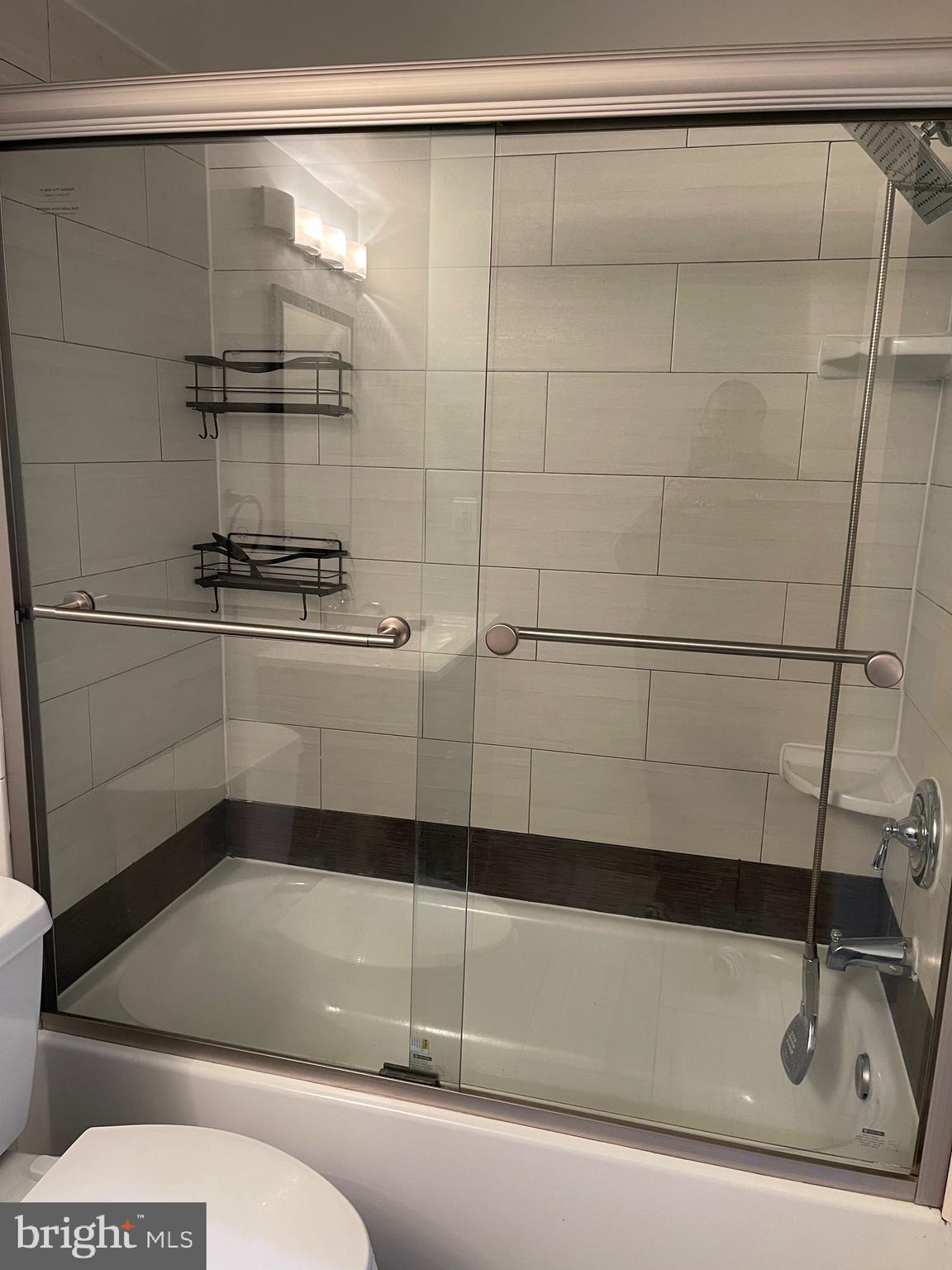 444 Girard Street, Unit 102 Gaithersburg, MD 20877 - Photo 14 of 30 a bathroom with a shower and mirror