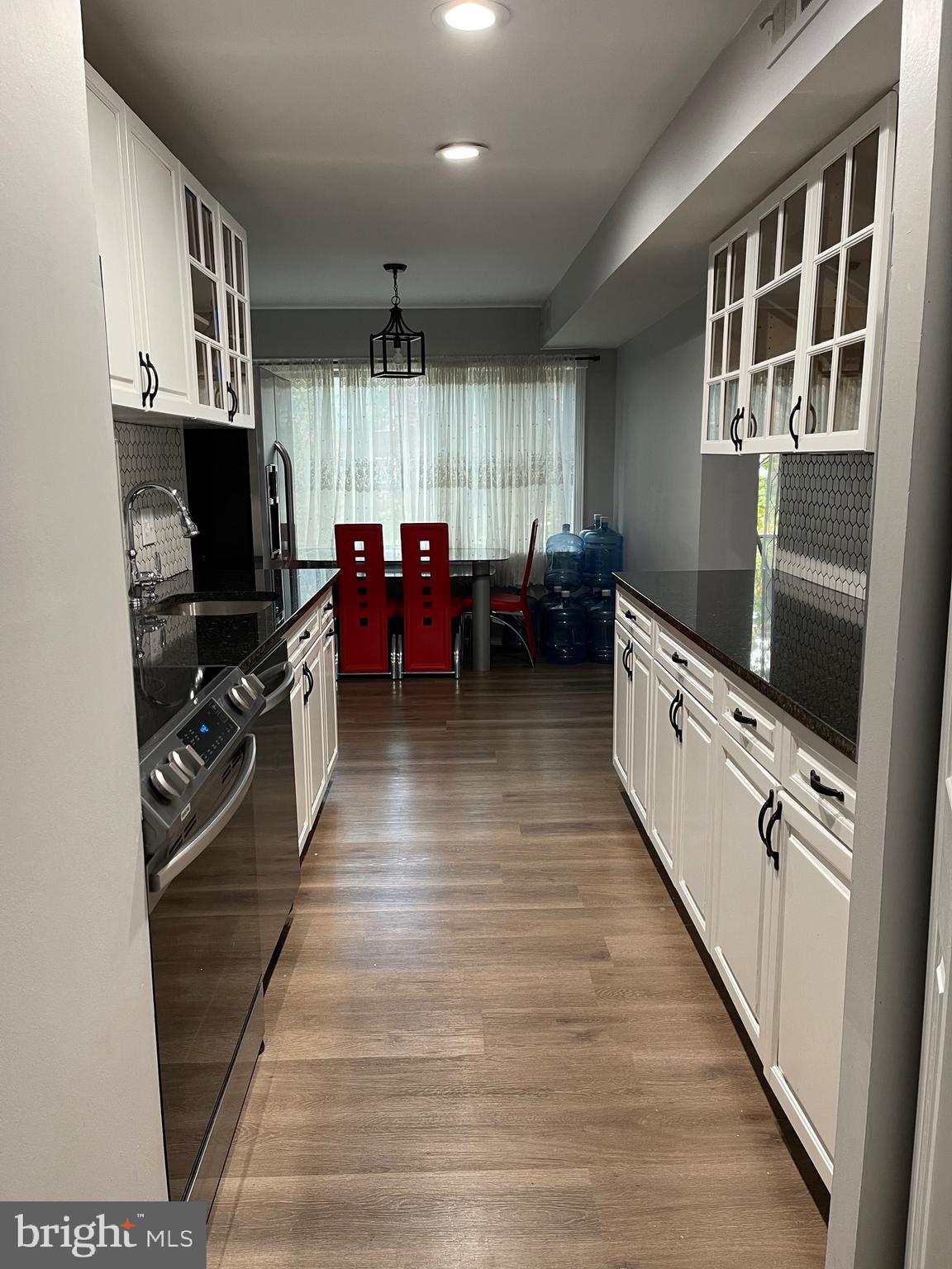 444 Girard Street, Unit 102 Gaithersburg, MD 20877 - Photo 17 of 30 a kitchen with granite countertop a stove top oven a sink dishwasher and a refrigerator