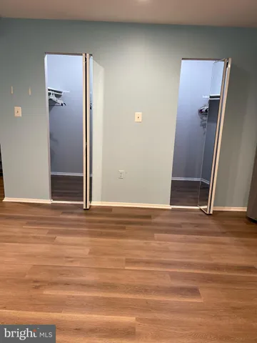 an empty room with wooden floor and entrance