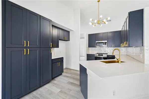 a kitchen with kitchen island granite countertop stainless steel appliances a sink refrigerator stove microwave and cabinets