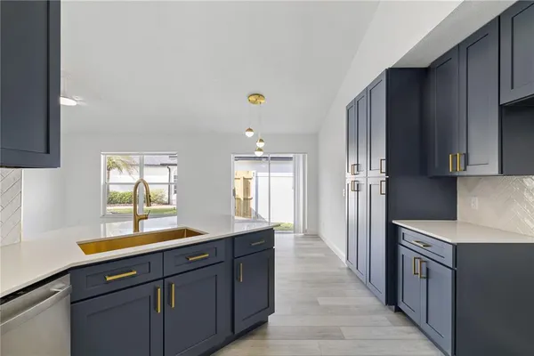 a kitchen with stainless steel appliances granite countertop a sink a stove a refrigerator and cabinets