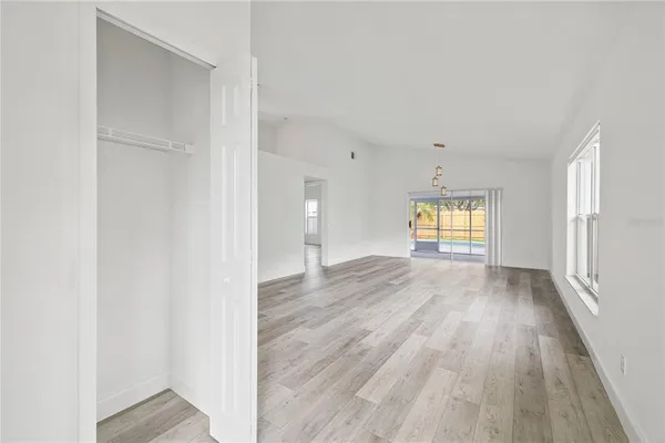 a view of empty room with window and wooden floor