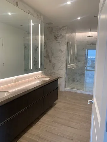 a bathroom with a double vanity sink a toilet and a shower