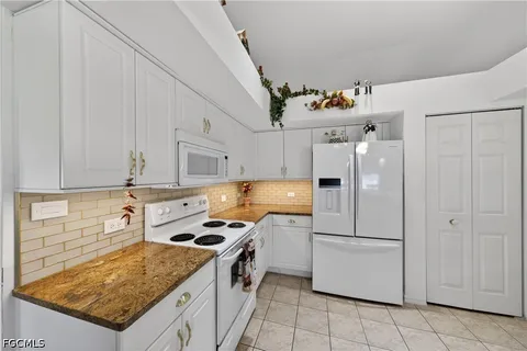 a kitchen with kitchen island granite countertop cabinets and steel appliances