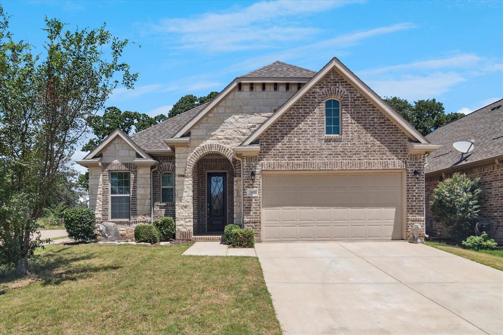 a front view of a house with a yard and garage