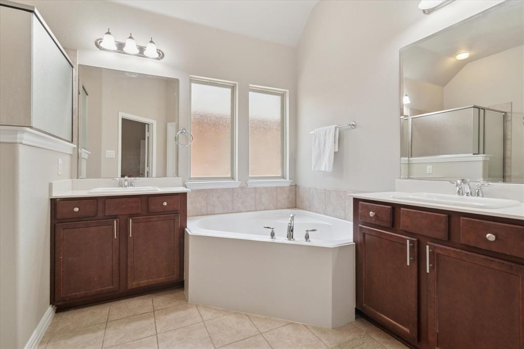 7401 Bishop Pine Road Denton, TX 76208 - Photo 16 of 25 a bathroom with a tub a sink double vanity and a mirror