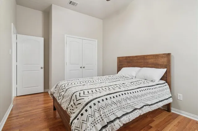a bedroom with a bed and wooden floor