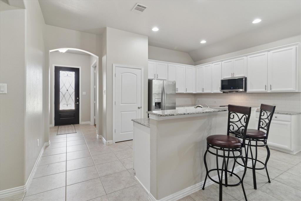 7401 Bishop Pine Road Denton, TX 76208 - Photo 4 of 25 a kitchen with stainless steel appliances granite countertop a refrigerator and microwave