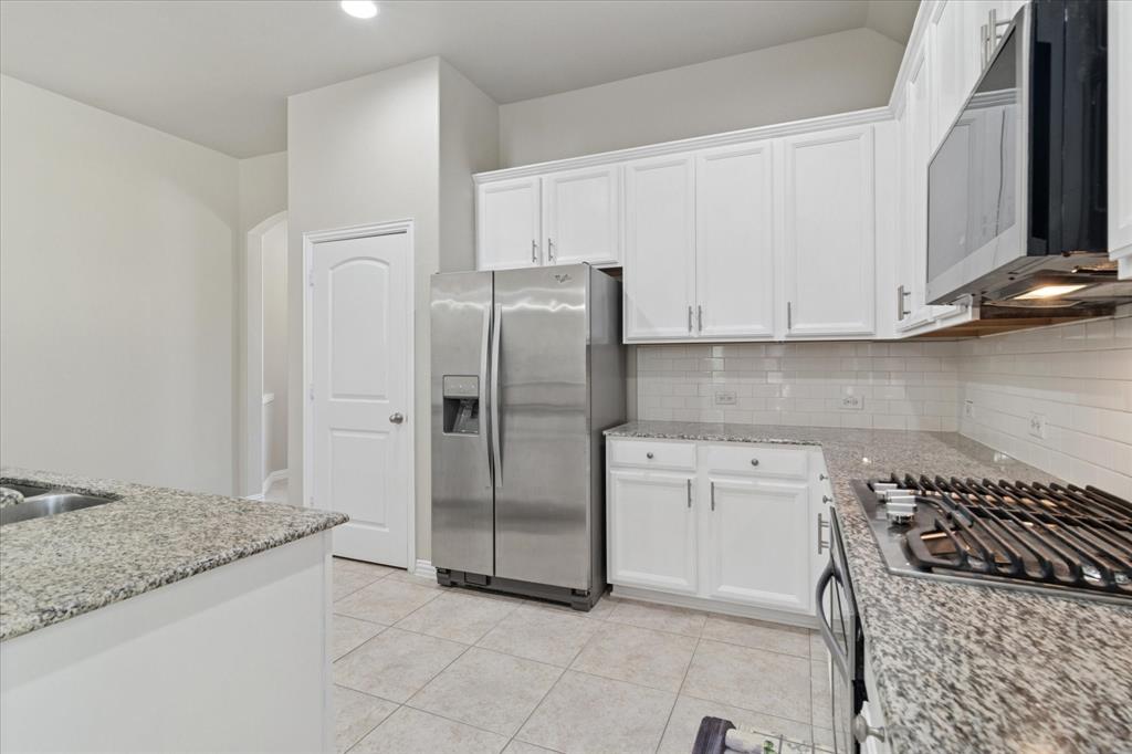 7401 Bishop Pine Road Denton, TX 76208 - Photo 5 of 25 a kitchen with stainless steel appliances granite countertop a refrigerator and a stove