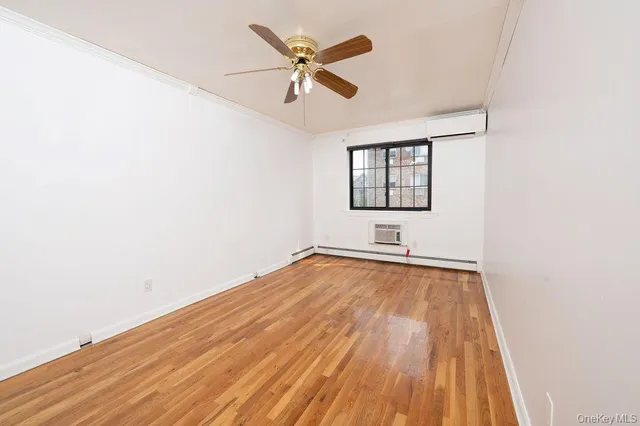 an empty room with a window and a ceiling fan