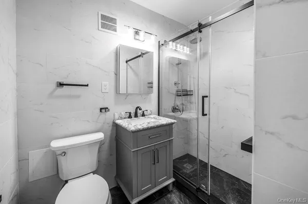 a bathroom with a granite countertop toilet sink and shower