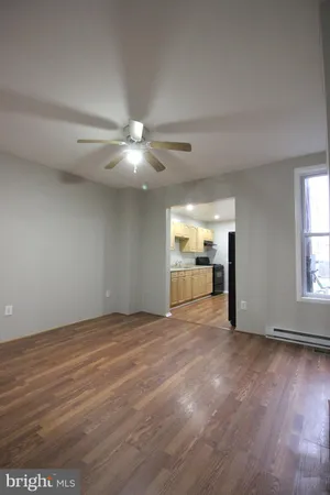 a view of an empty room with window and wooden floor