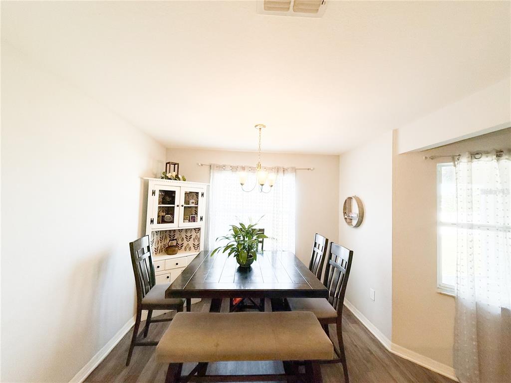 233 Cattail Way Lake Alfred, FL 33850 - Photo 8 of 25 a view of a dining room with furniture and wooden floor