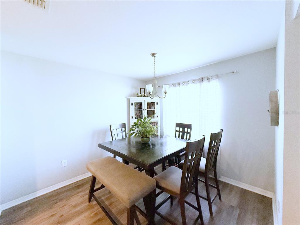 233 Cattail Way Lake Alfred, FL 33850 - Photo 9 of 25 a view of a dining room with furniture and wooden floor