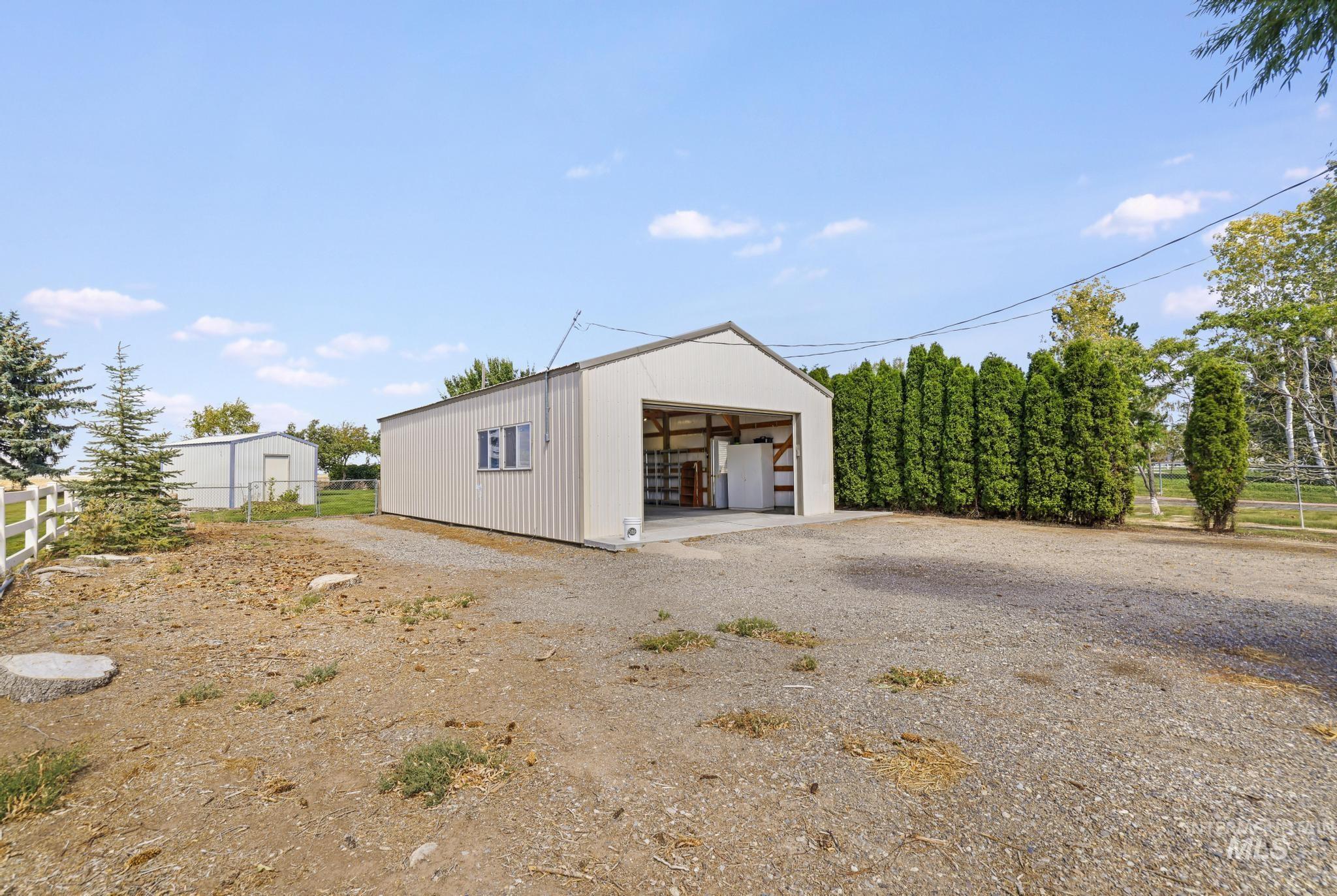 918 West Baseline Road Paul, ID 83347 - Photo 4 of 47 Metal outbuilding with a large garage door opening and three fixed windows