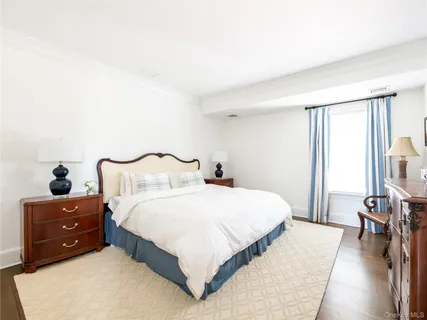a bedroom with a bed and a flat tv screen on a dresser